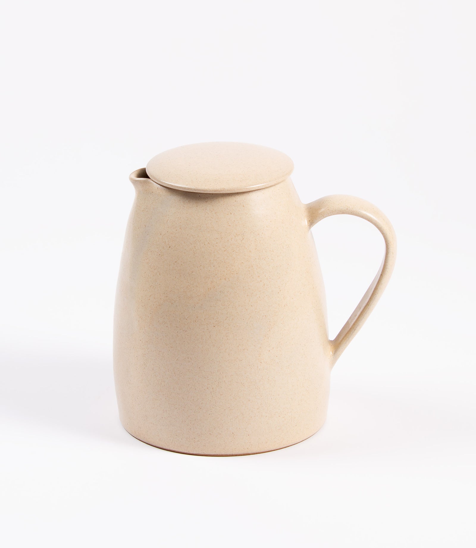 Beige ceramic pitcher with lid on a white background