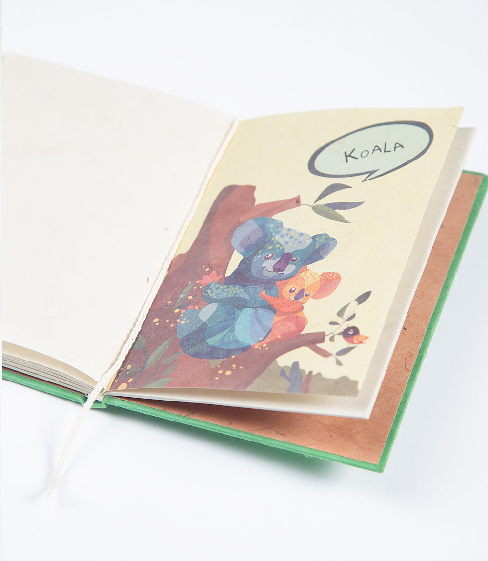 Open book with a colorful illustration of a koala and a child in a tree, with a speech bubble saying &#39;Koala&#39;.