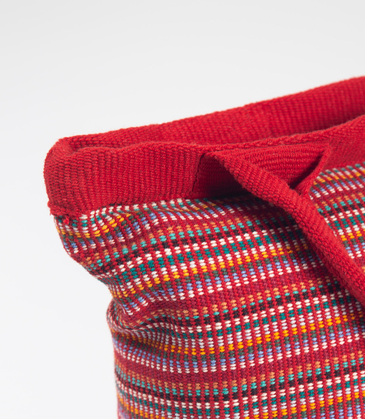 Close-up of a red fabric with a multicolored pattern on a white background