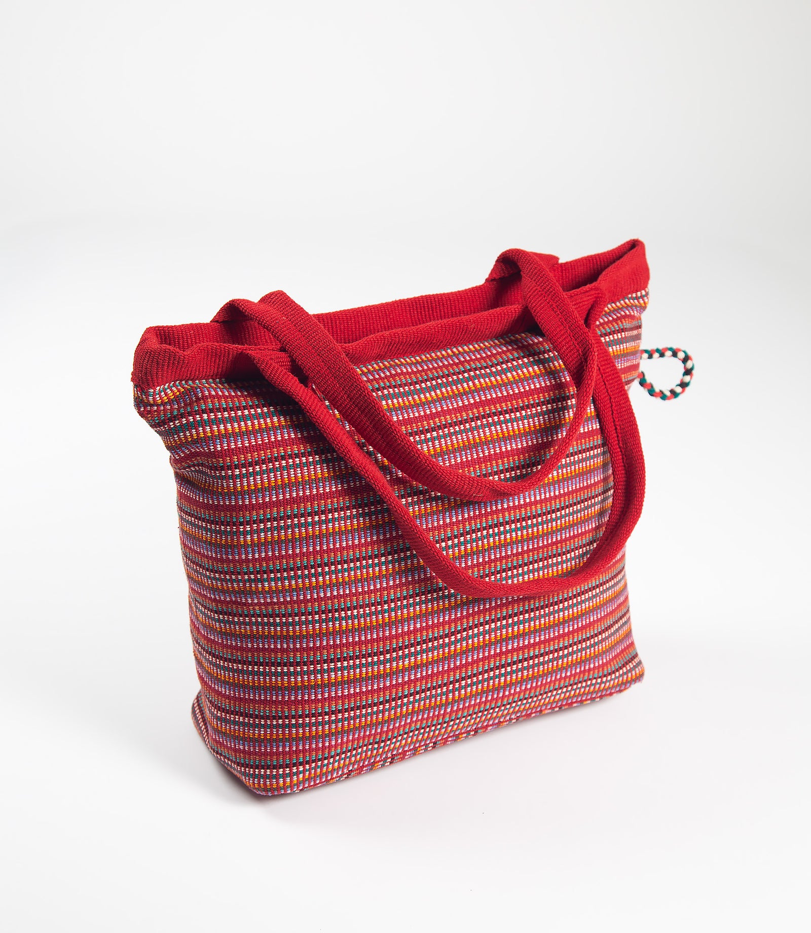 Handbag with red handle and multicolored body on a white background