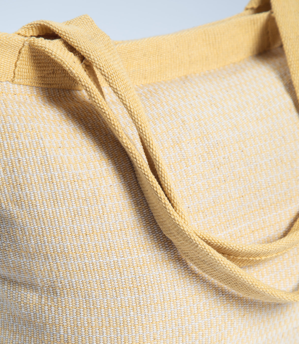 Close-up of a yellow textured fabric with a light blue background