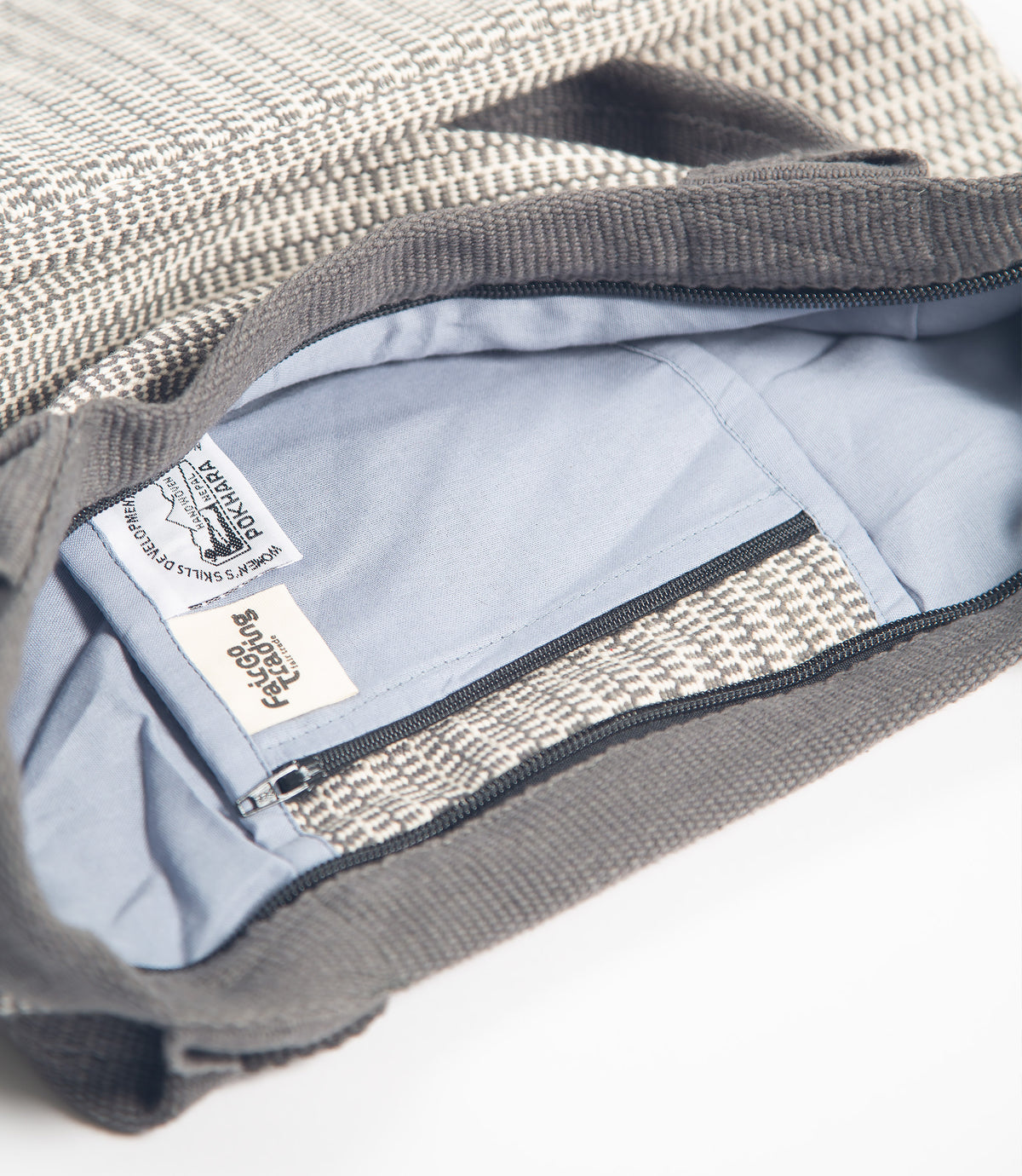 Close-up of a gray textured bag with a visible brand label on a white background
