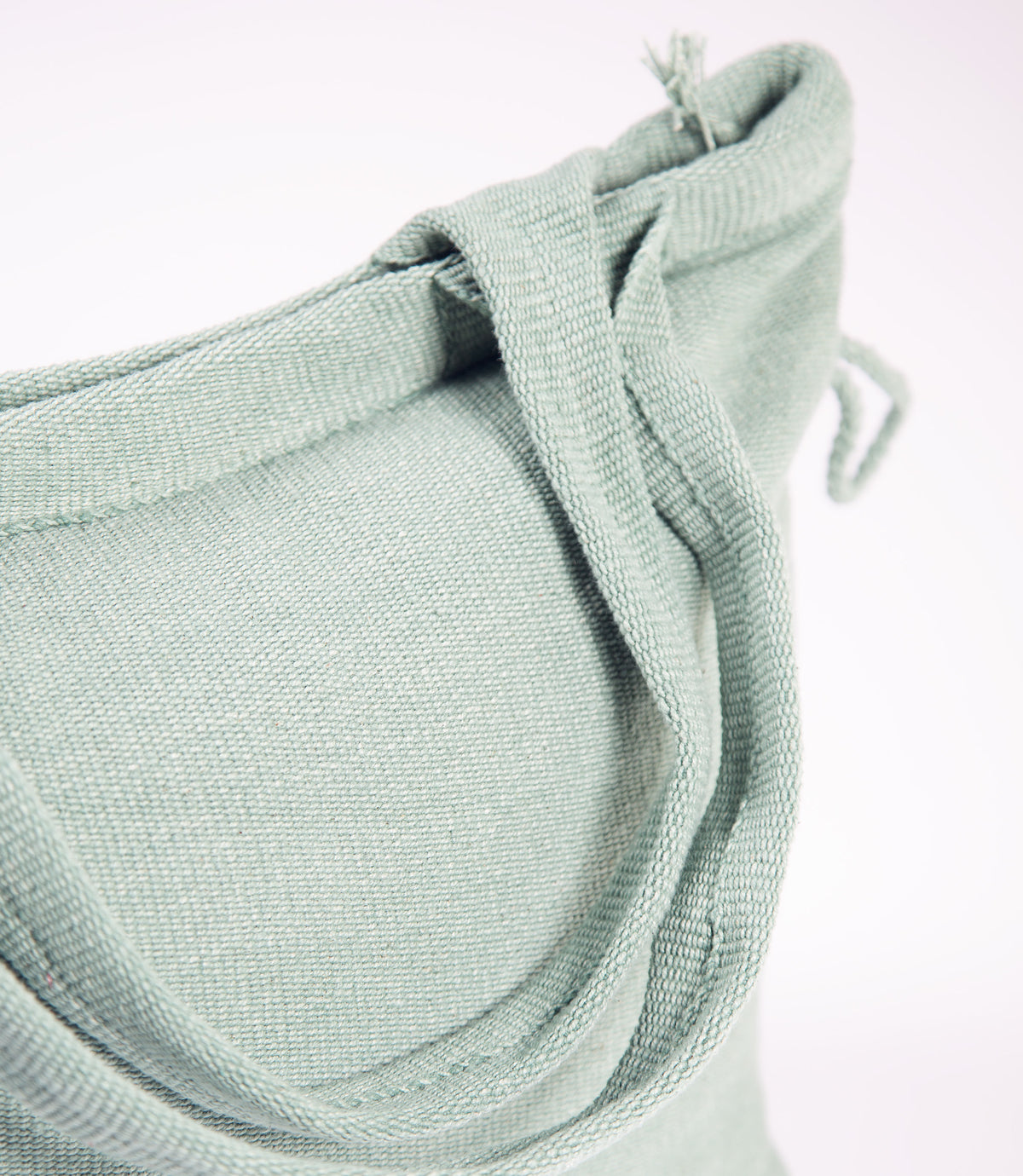 Close-up of a light green fabric with a textured pattern on a white background
