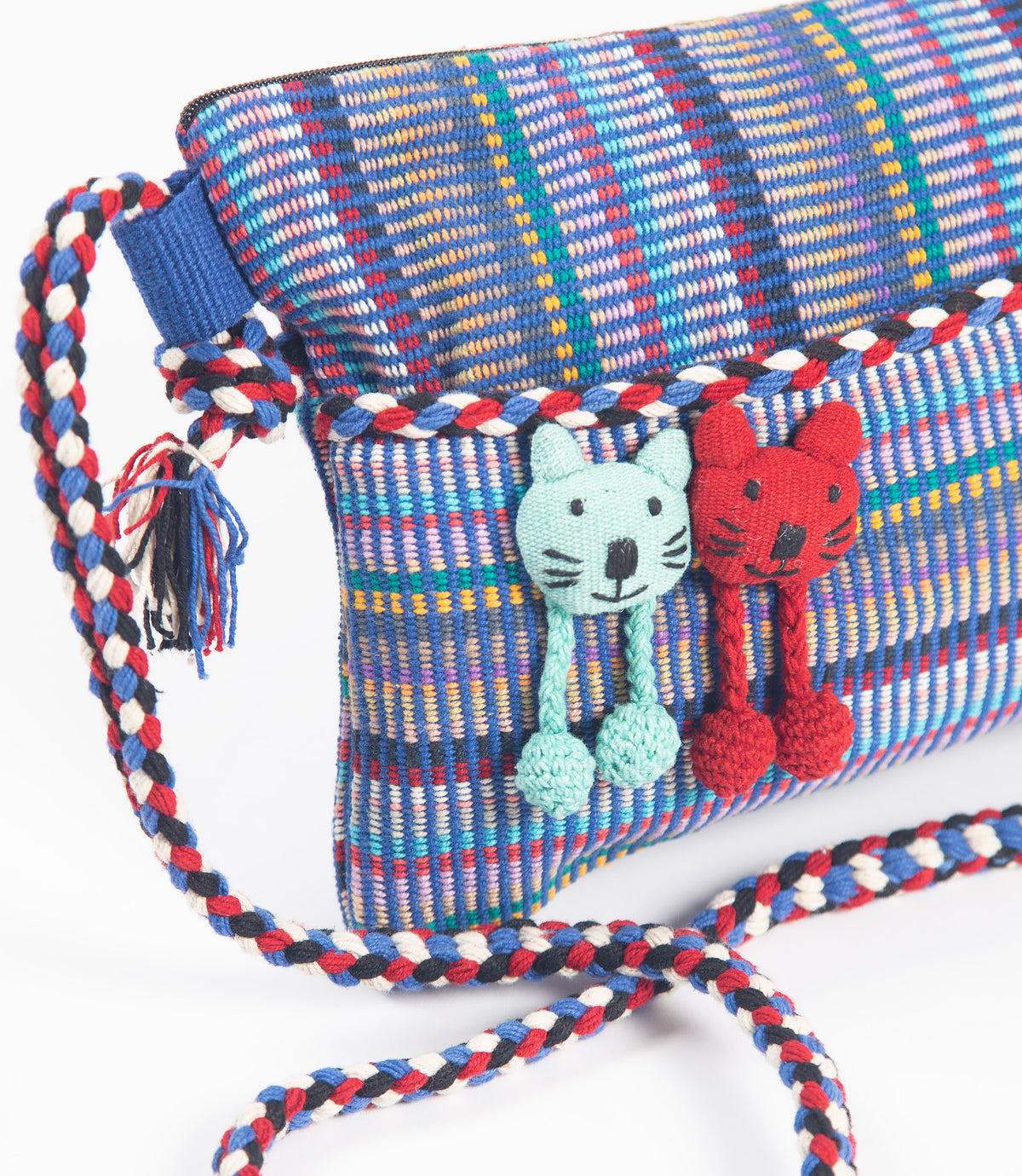 Colorful woven bag with cat-themed tassels on a white background