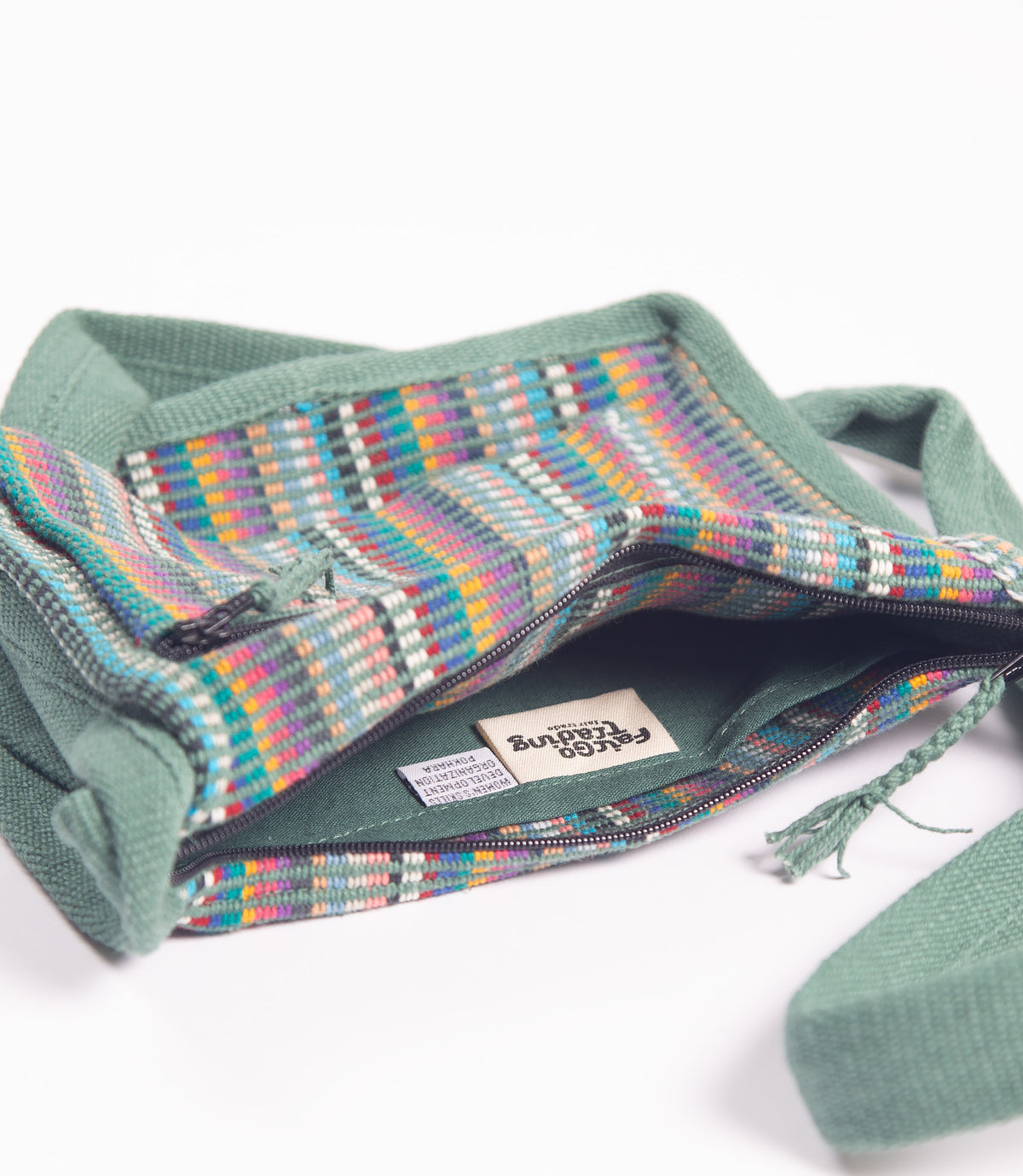 Woven bag with colorful pattern and green handle on a white background