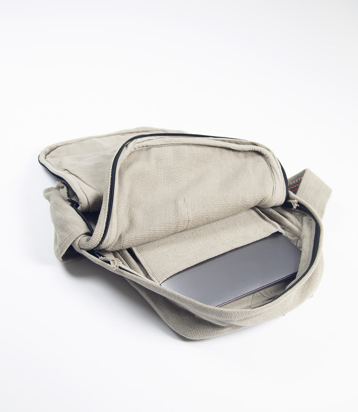 Open light grey backpack with a laptop inside on a white background