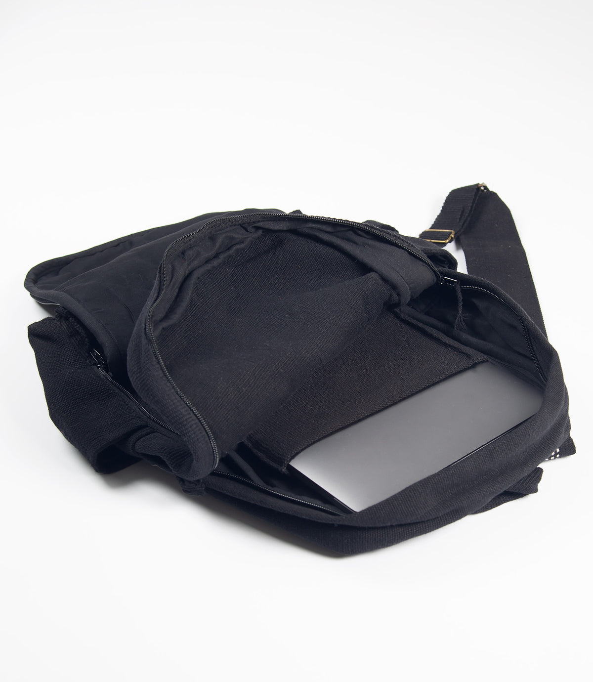 Black backpack showing laptop inside on a white background
