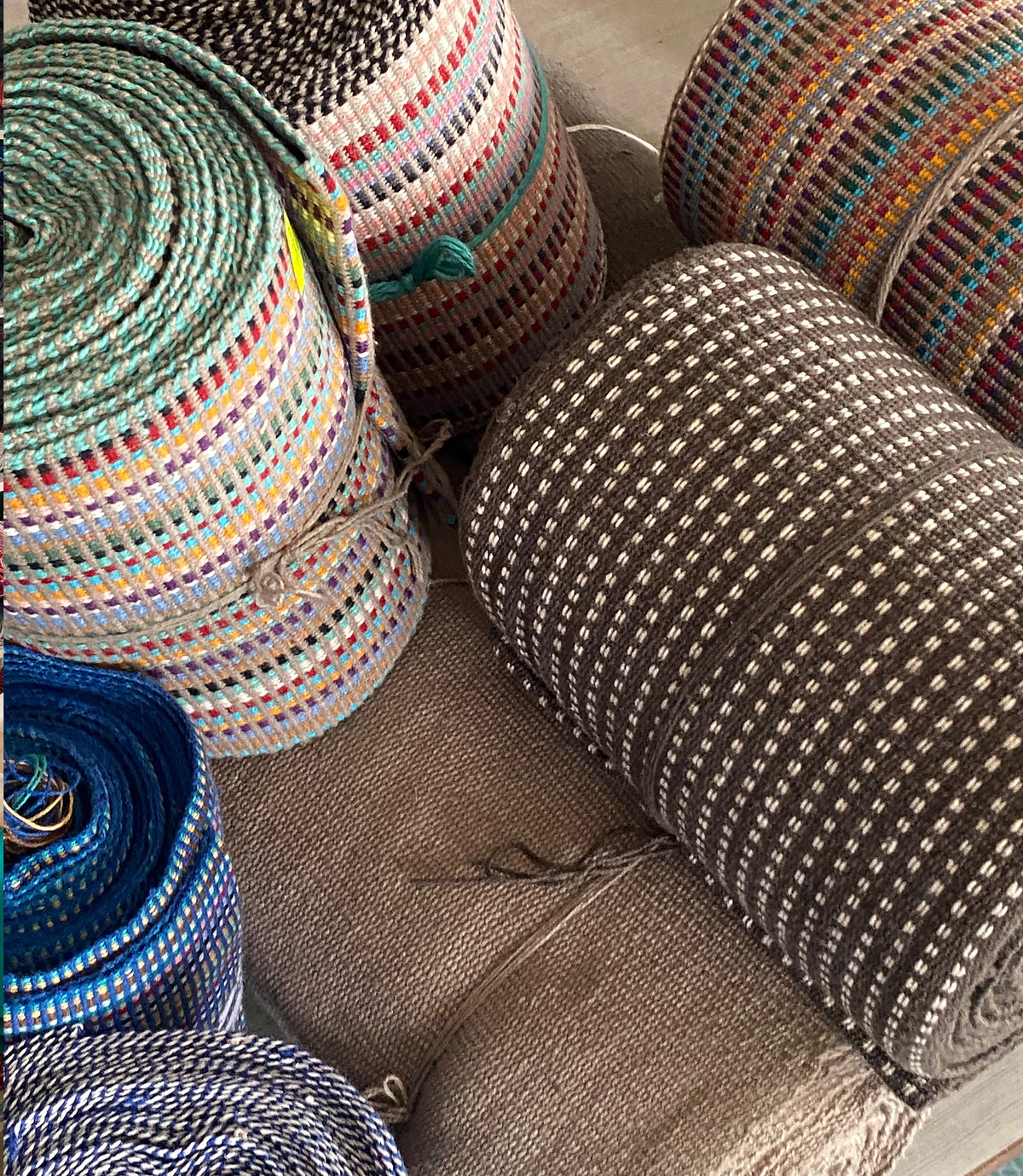 Stack of colorful woven rolls ready to be woven