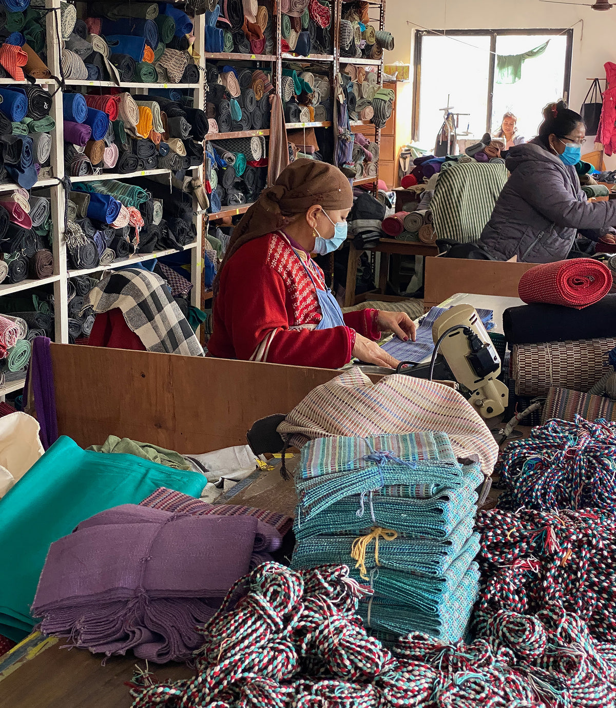 Artisans working with yarn and fabric in a textile workshop