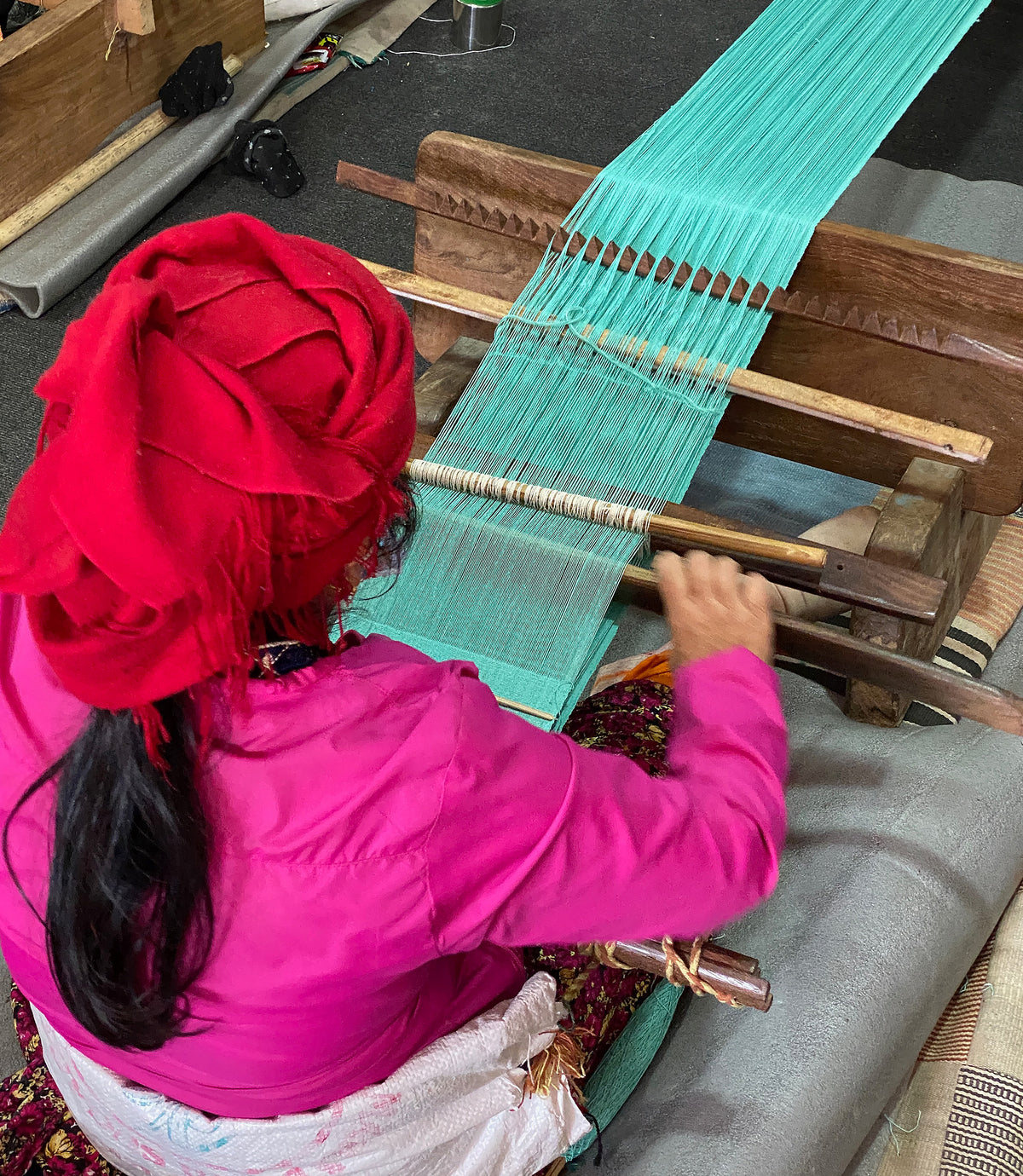 Close up of an artisan using looms in a textile workshop