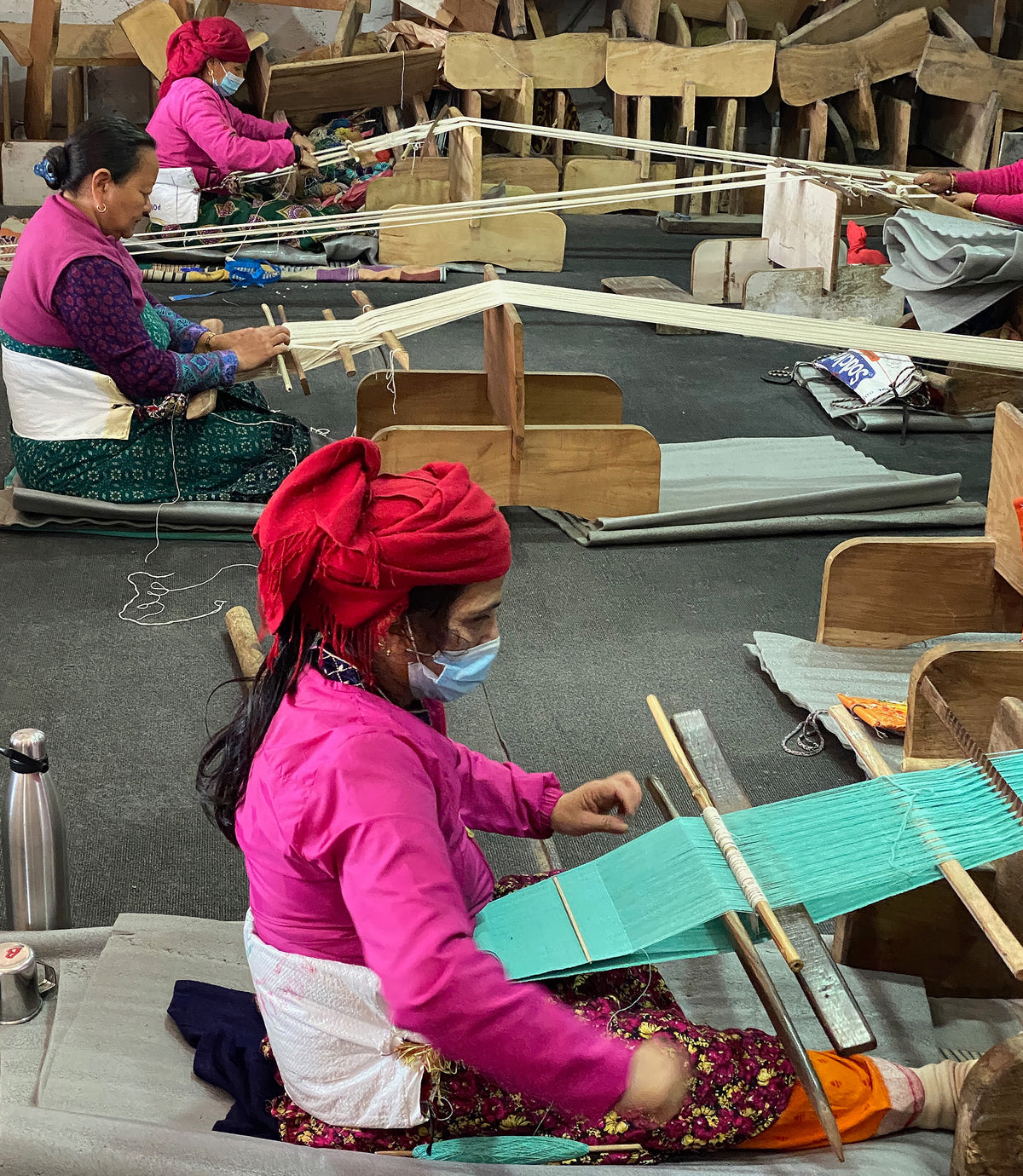 Producers using looms in a textile workshop