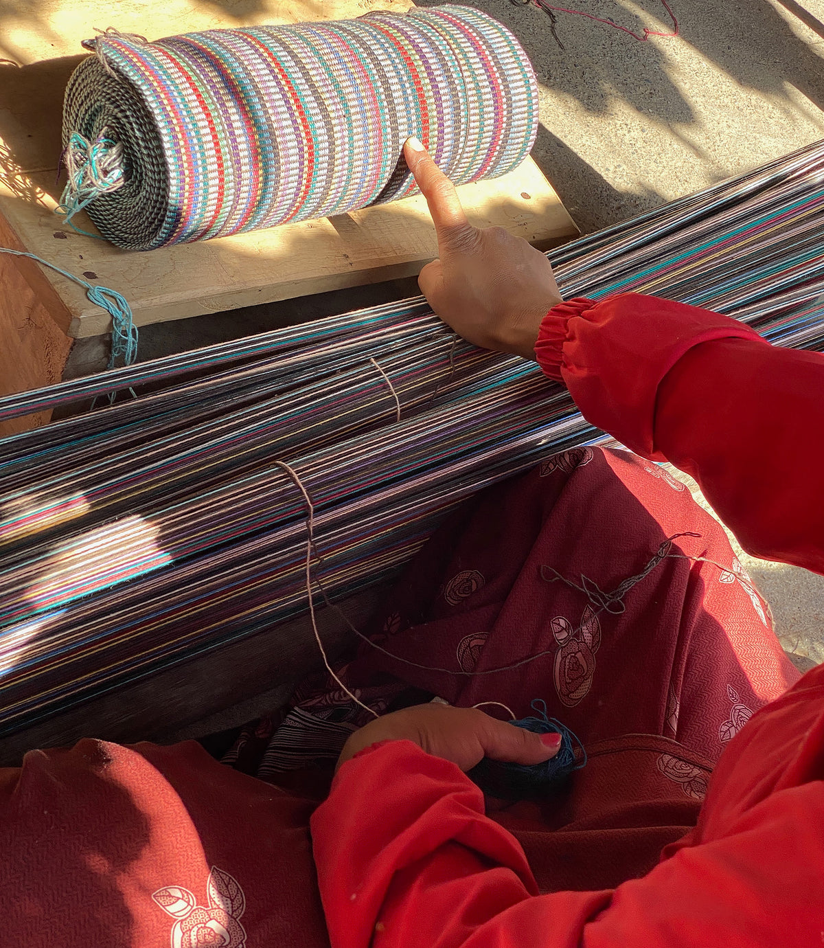 Artisan working with colorful fabric on a loom