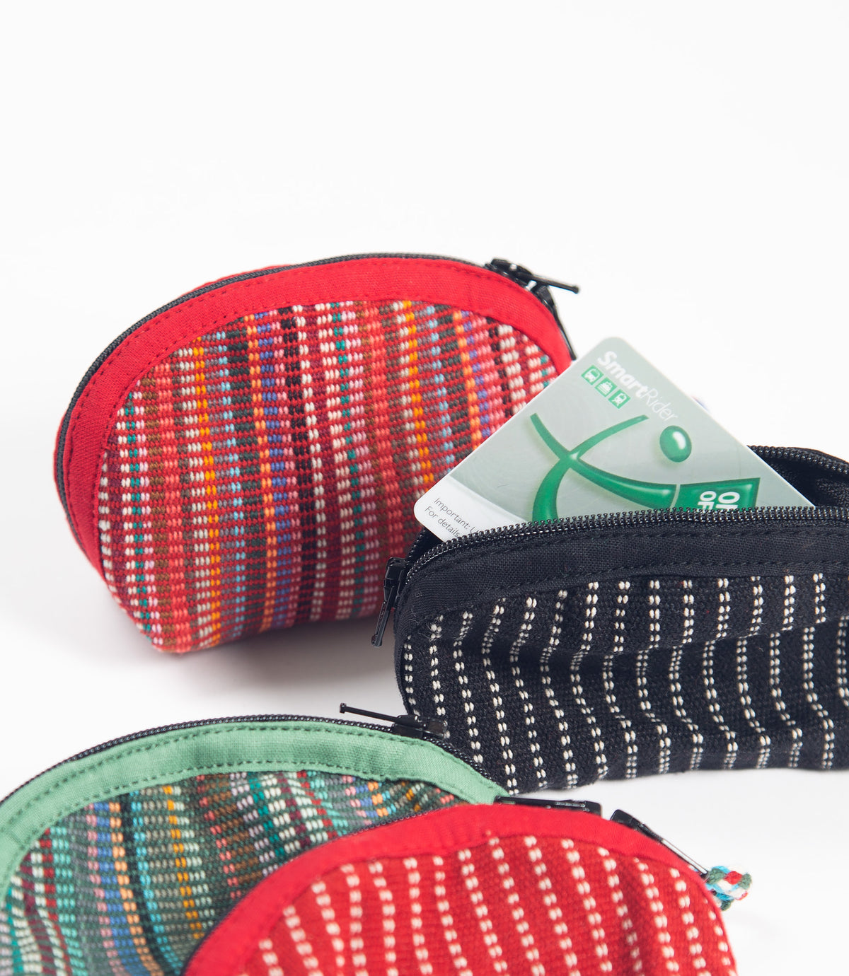 Four patterned key purses with a transport card in one of them on a white background
