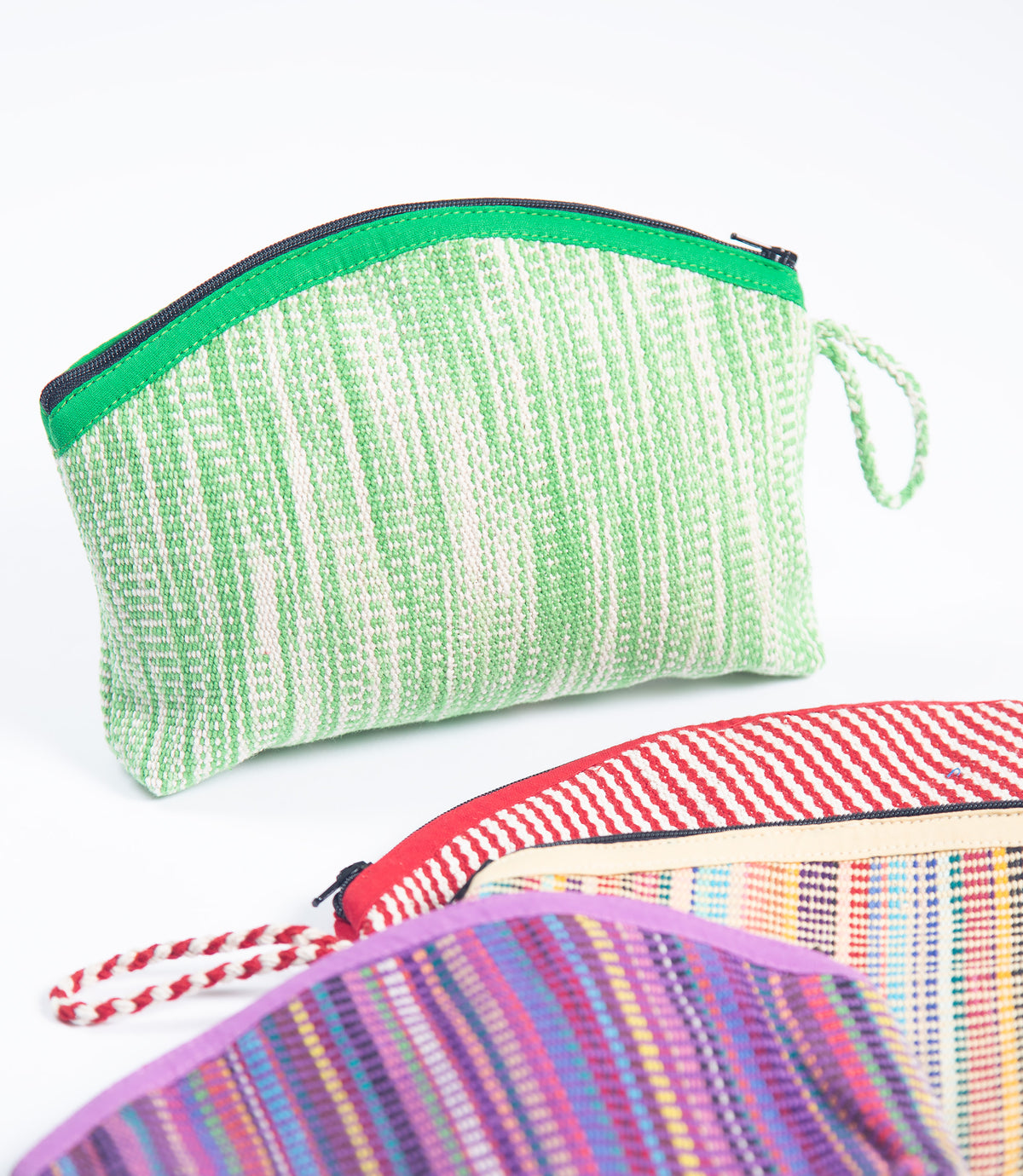 Four colorful fabric pouches with zippers on a white background