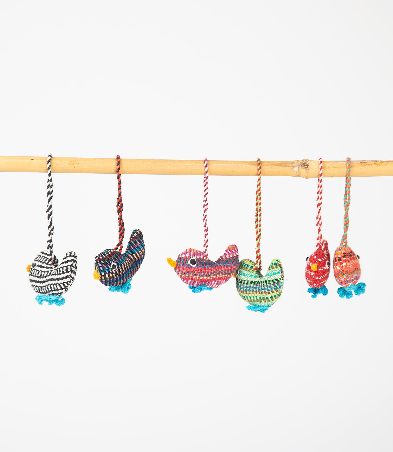 Colorful bird-shaped hanging toys on a stick against a white background