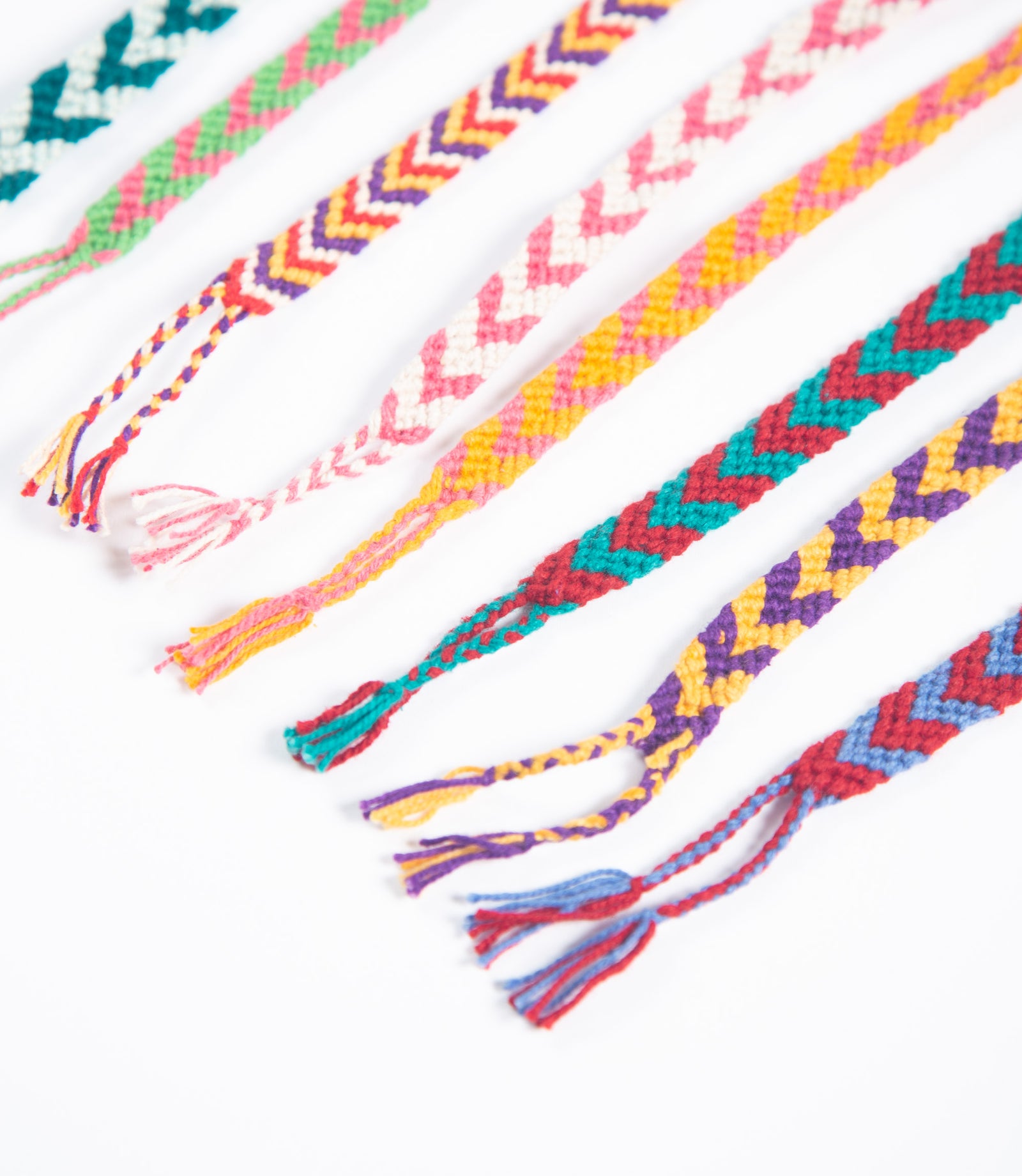 Colorful braided bracelets on a white background