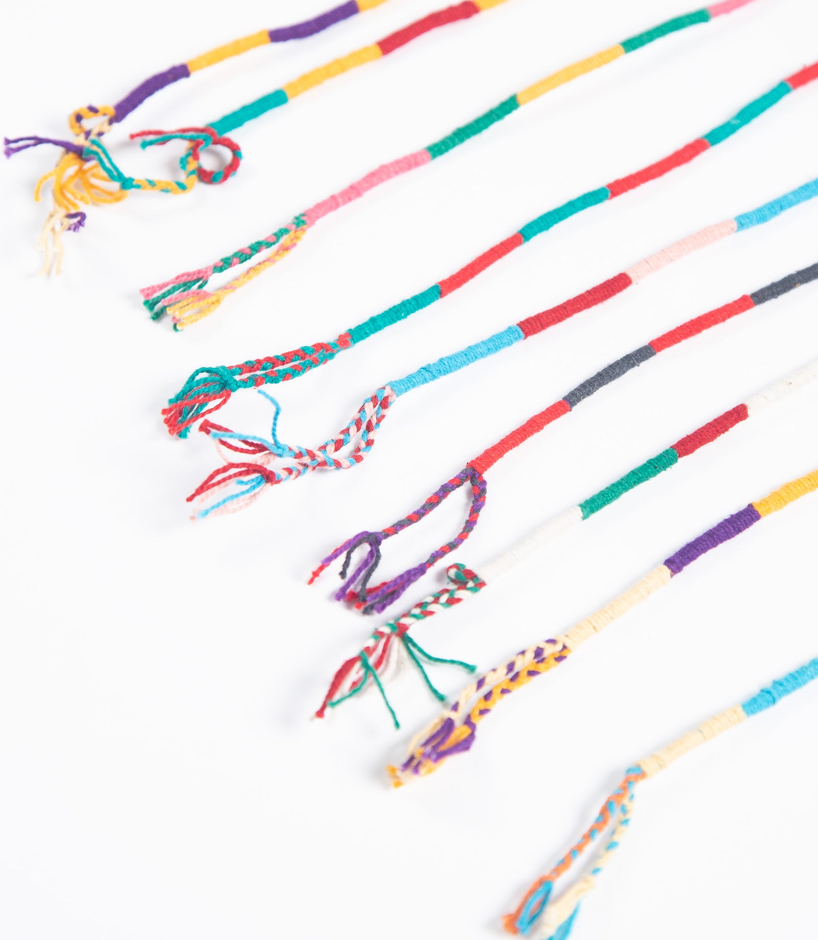 Colorful braided bracelets on a white background
