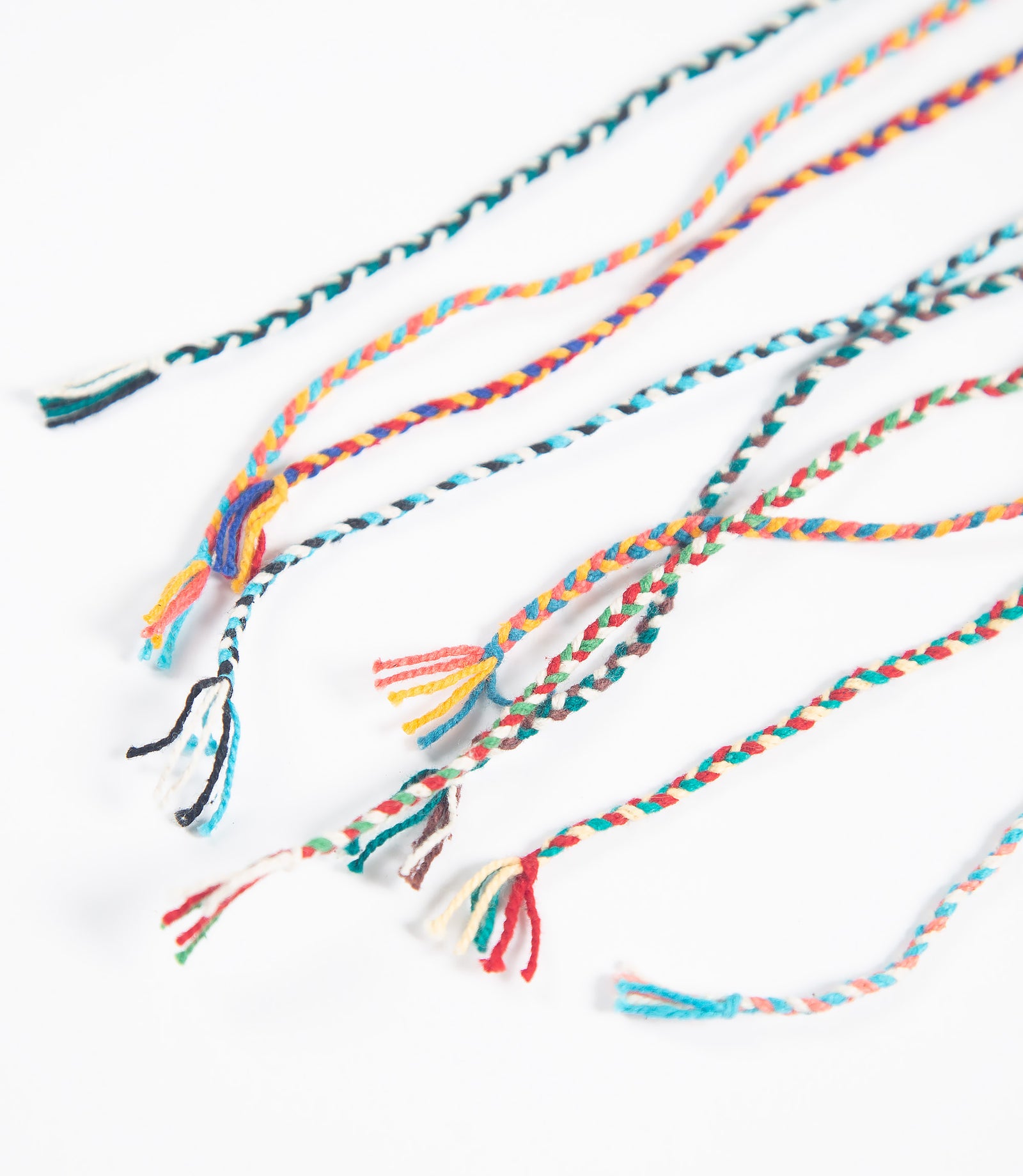 Colorful thin braided bracelets on a white background