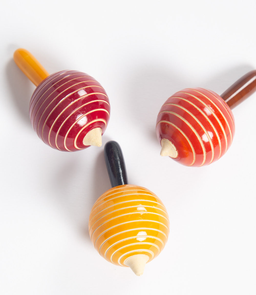 Set of three colorful wooden spinning tops.