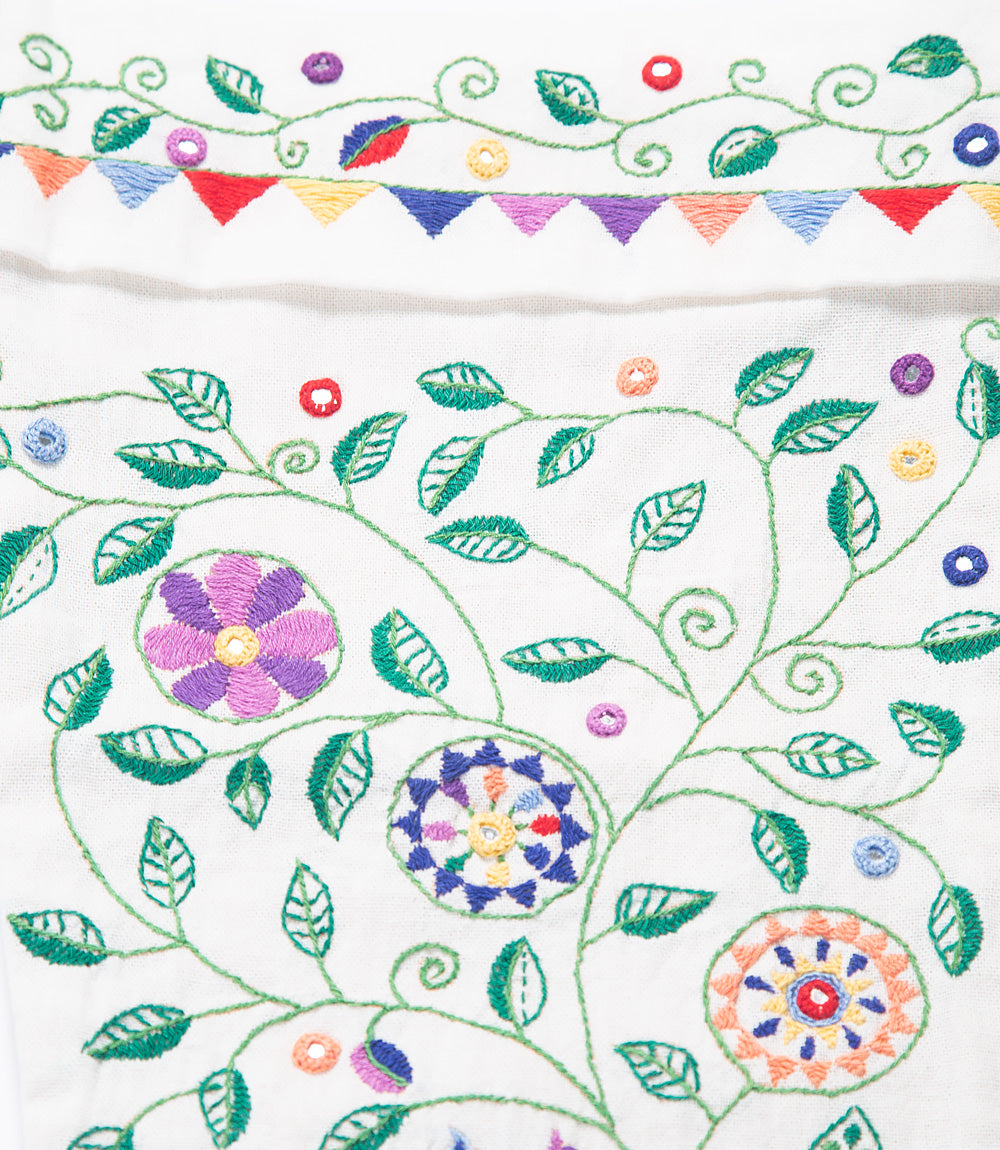Embroidered fabric with colorful floral and leaf patterns on a white background
