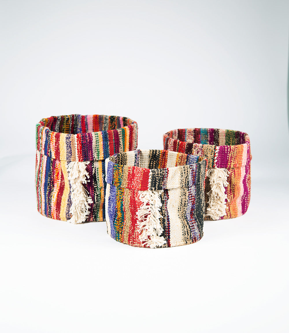 A set of three multicolored folding baskets with fringe detailing, made from upcycled saree fabric.