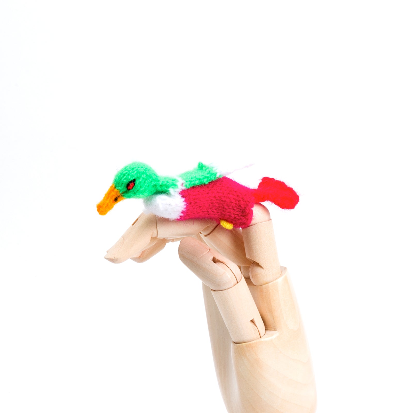 A colorful duck finger puppet on a wooden hand model